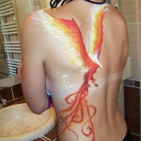 Красивая татуировка у девушки на спине в виде жар-птицы