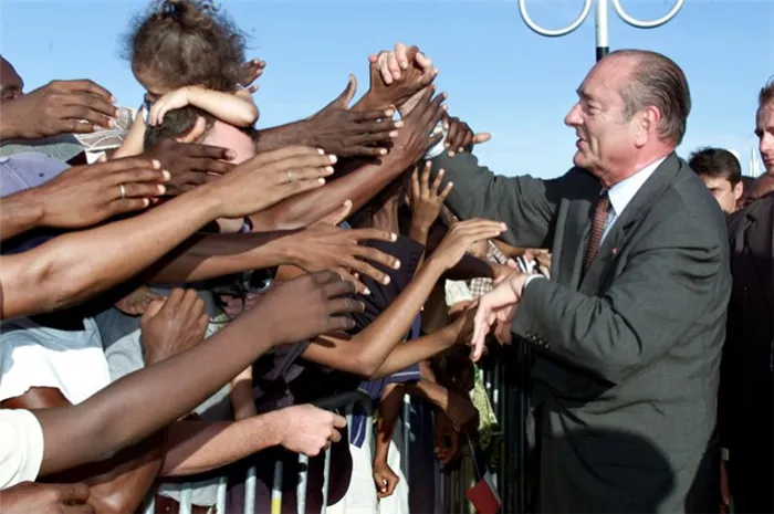 Жак Ширак обменивается рукопожатиями с местными жителями по прибытии в аэропорт заморского региона Франции Майотта, 2001 год.