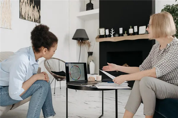 Астролог показывает девочке схему натальной карты на компьютере