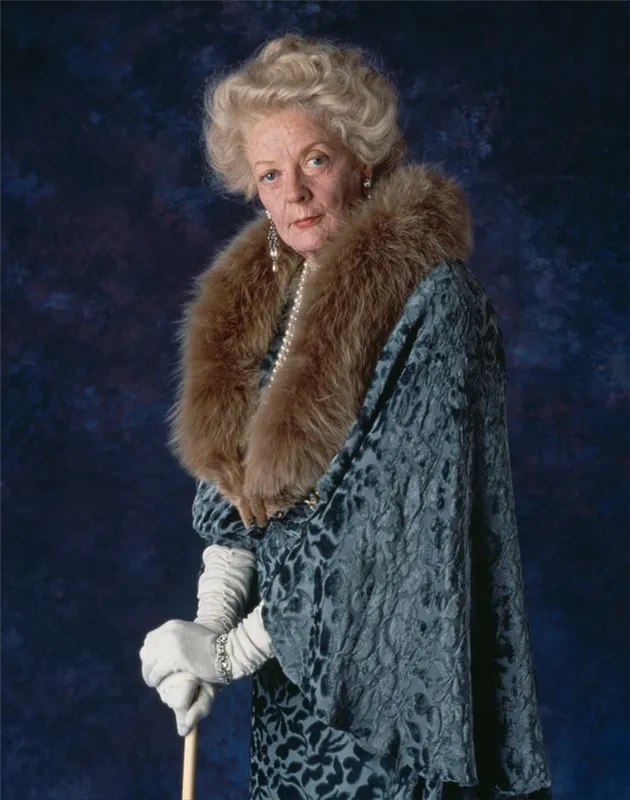 British actress Maggie Smith on the set of Spielberg's film Hook, Maggie Smith stands dressed in an opulent, old-fashioned outfit with a fur collar draped around her neck.